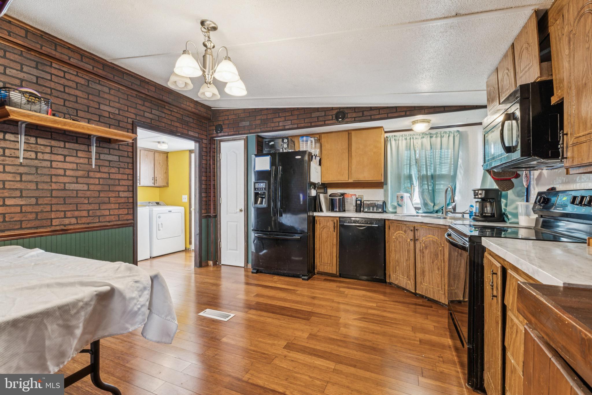 10237 Hook Road Rapidan, VA 22733 - Photo 19 of 37 a kitchen with stainless steel appliances granite countertop a refrigerator a stove top oven a sink dishwasher and wooden cabinets with wooden floor