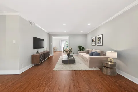 a living room with furniture flat screen tv and couches
