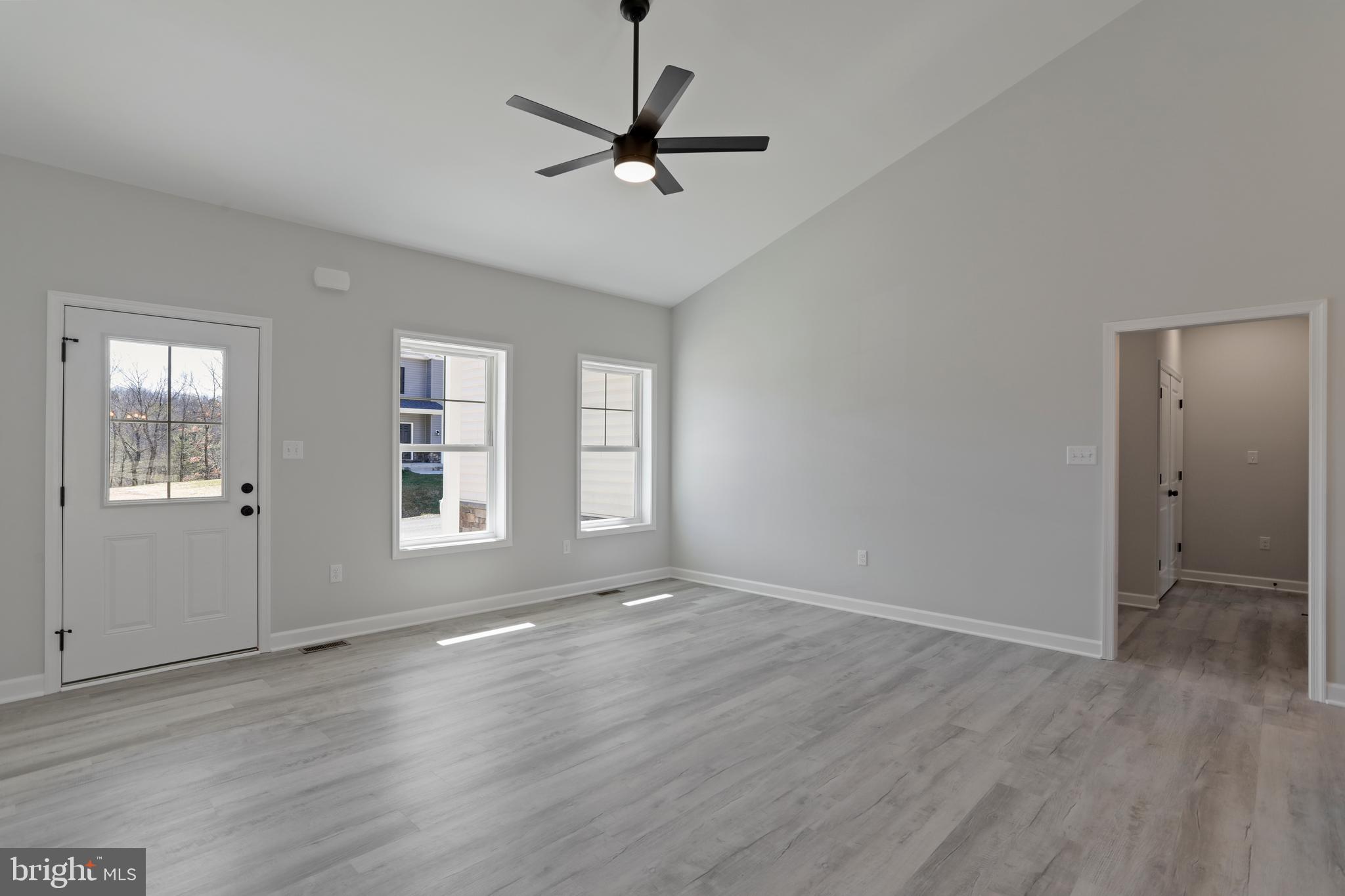 32 Larimar Lane Inwood, WV 25428 - Photo 6 of 28 an empty room with wooden floor fan and windows