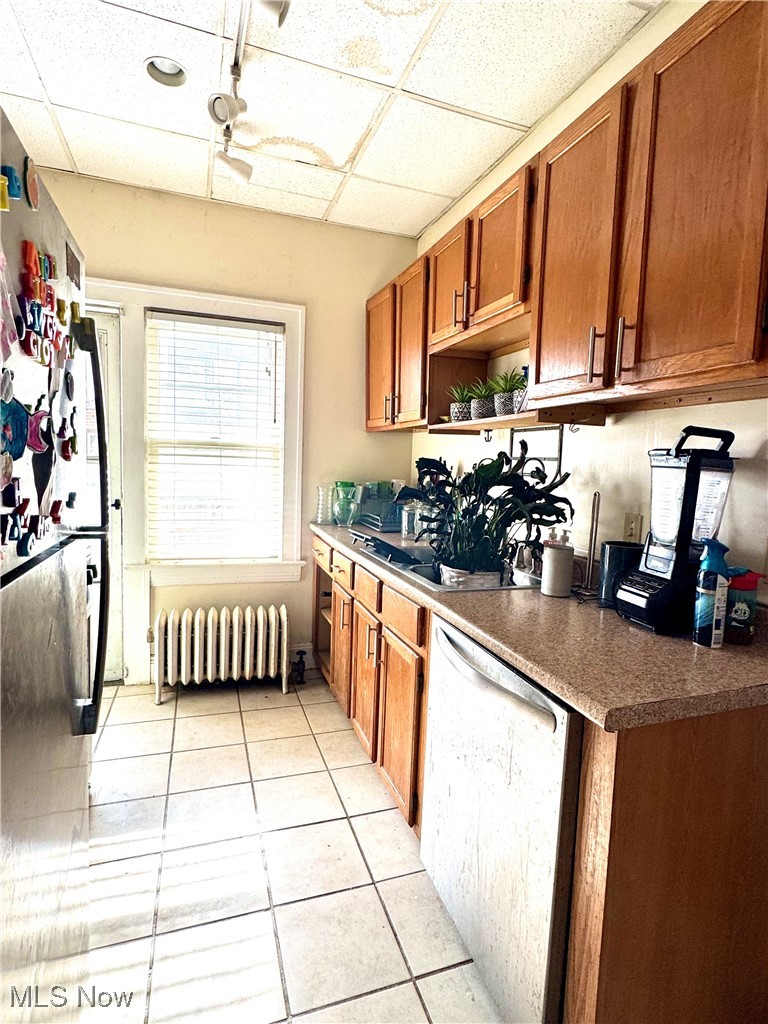 2152 Middlefield Road Cleveland, OH 44106 - Photo 30 of 50 Kitchen with radiator, light tile patterned floors, a paneled ceiling, dishwasher, and ceiling fan