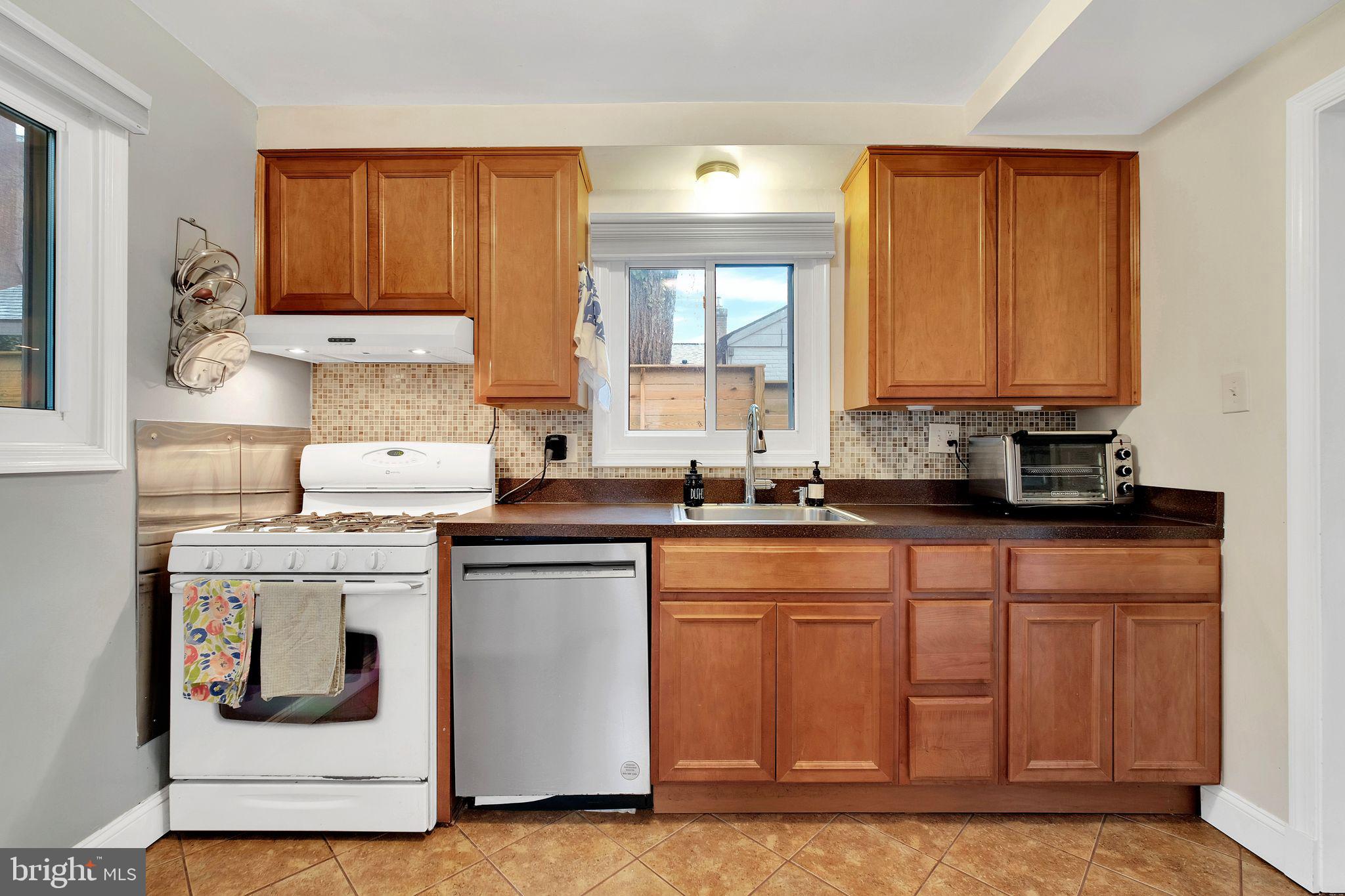 2204 Prichard Road Silver Spring, MD 20902 - Photo 9 of 26 a kitchen with stainless steel appliances granite countertop a stove a sink and a microwave