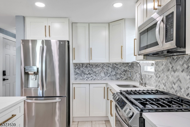47 Ekings Avenue Hawthorne, NJ 07506 - Photo 4 of 12 a kitchen with stainless steel appliances granite countertop a sink stove and refrigerator