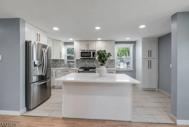 a kitchen with stainless steel appliances a refrigerator sink and stove