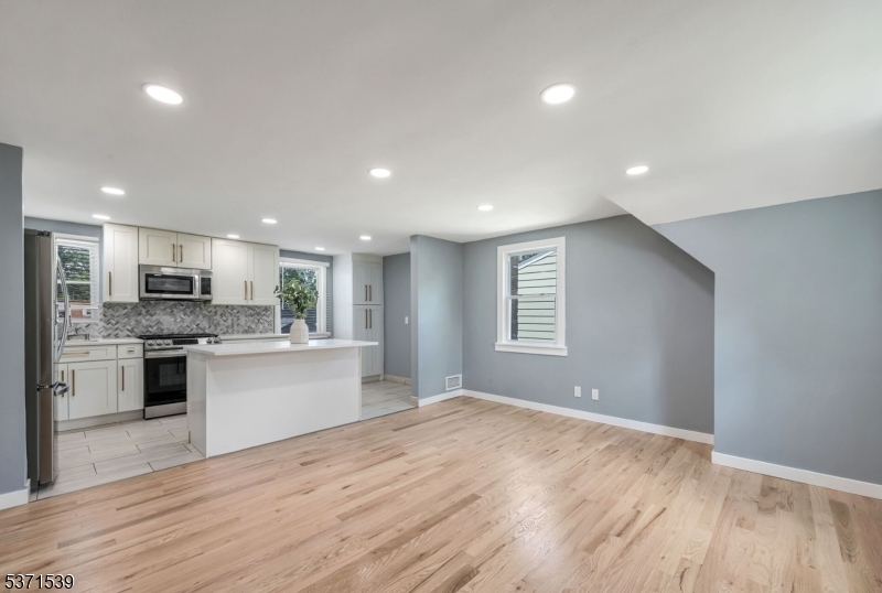 47 Ekings Avenue Hawthorne, NJ 07506 - Photo 8 of 12 a large kitchen with kitchen island a sink dishwasher a stove and a refrigerator with wooden floor