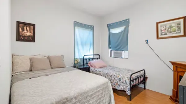 a bedroom with two beds and painting on the wall