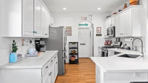 a kitchen with a sink a refrigerator and cabinets