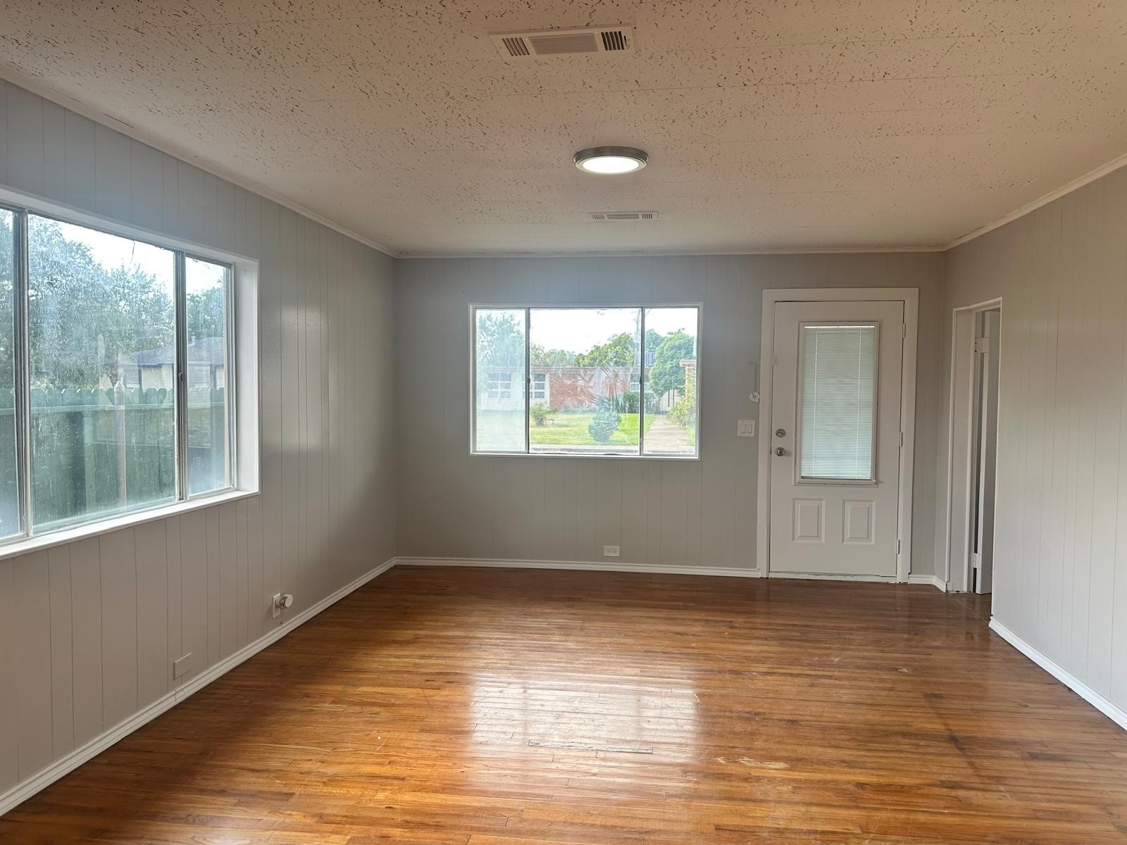 918 West 5th Street, Unit 1 Freeport, TX 77541 - Photo 5 of 21 a view of an empty room with wooden floor and a window