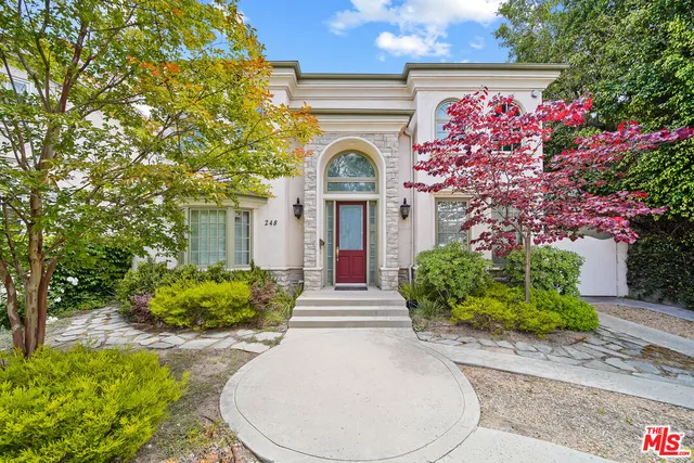 a front view of a house with a garden
