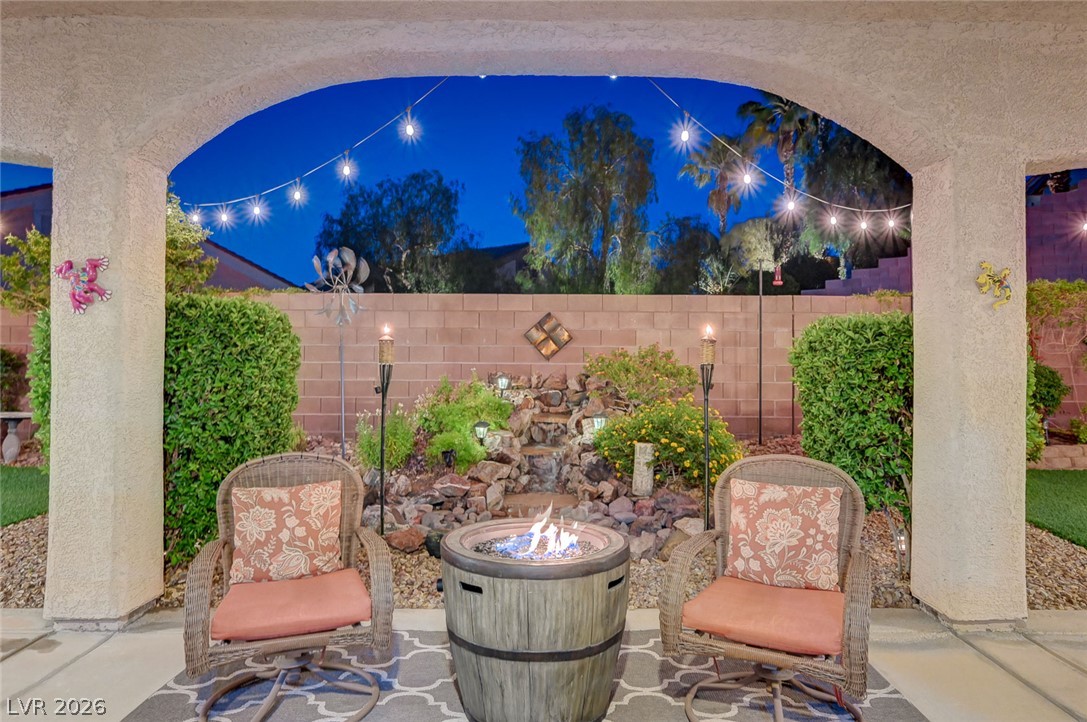 1604 Cattle Ranch Place Henderson, NV 89002 - Photo 4 of 99 An inviting covered patio featuring a central fire pit, perfect for evening gatherings.