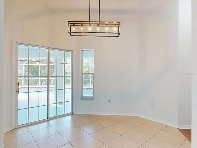 an empty room with a window and ceiling fan