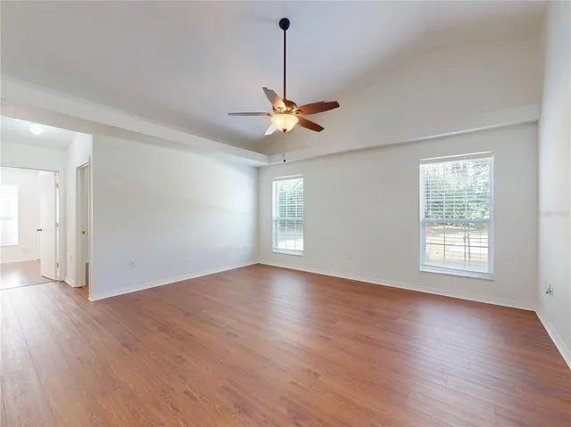 a view of an empty room with a floor to ceiling window and a ceiling fan