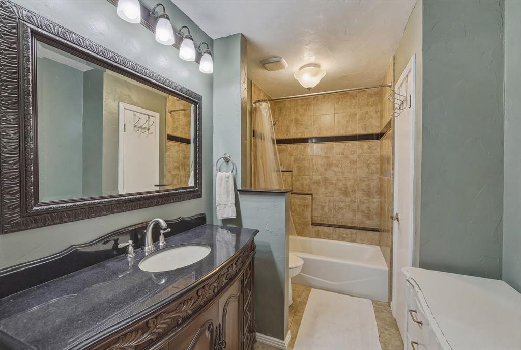 10203 Crestview Drive Tyler, TX 75707 - Photo 12 of 25 a bathroom with a granite countertop sink mirror vanity and a bathtub
