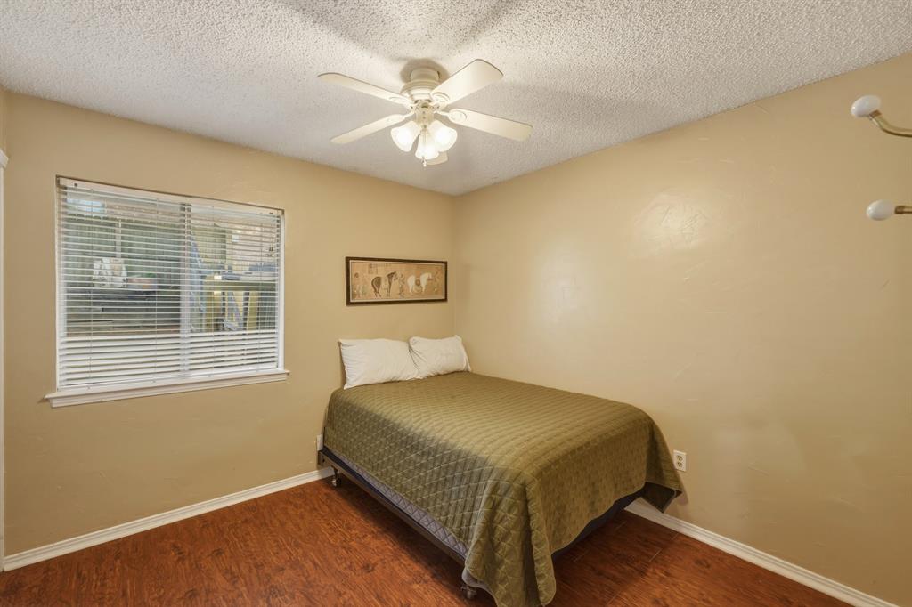 10203 Crestview Drive Tyler, TX 75707 - Photo 15 of 25 a bedroom with a bed and a chandelier