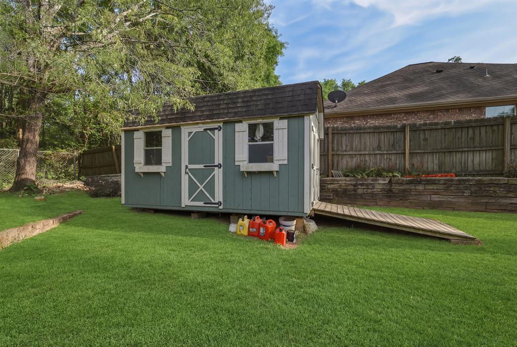 10203 Crestview Drive Tyler, TX 75707 - Photo 21 of 25 a view of a backyard with a garden and deck