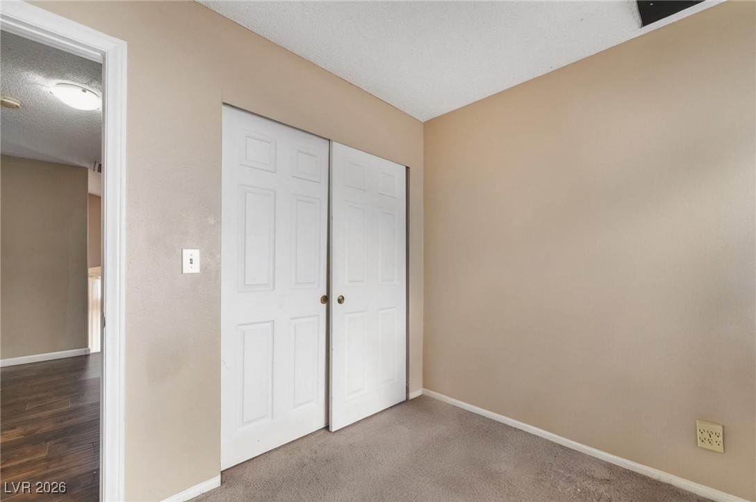 300 Redondo Street Henderson, NV 89014 - Photo 20 of 29 Unfurnished bedroom with a closet, a textured ceiling, and carpet flooring