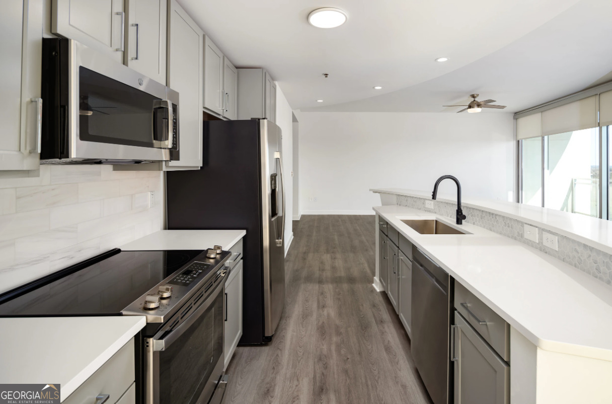 3242 Peachtree Road Northeast, Unit 1408 Atlanta, GA 30305 - Photo 1 of 41 a kitchen with stainless steel appliances a sink dishwasher a stove top oven a refrigerator with wooden floor and cabinets