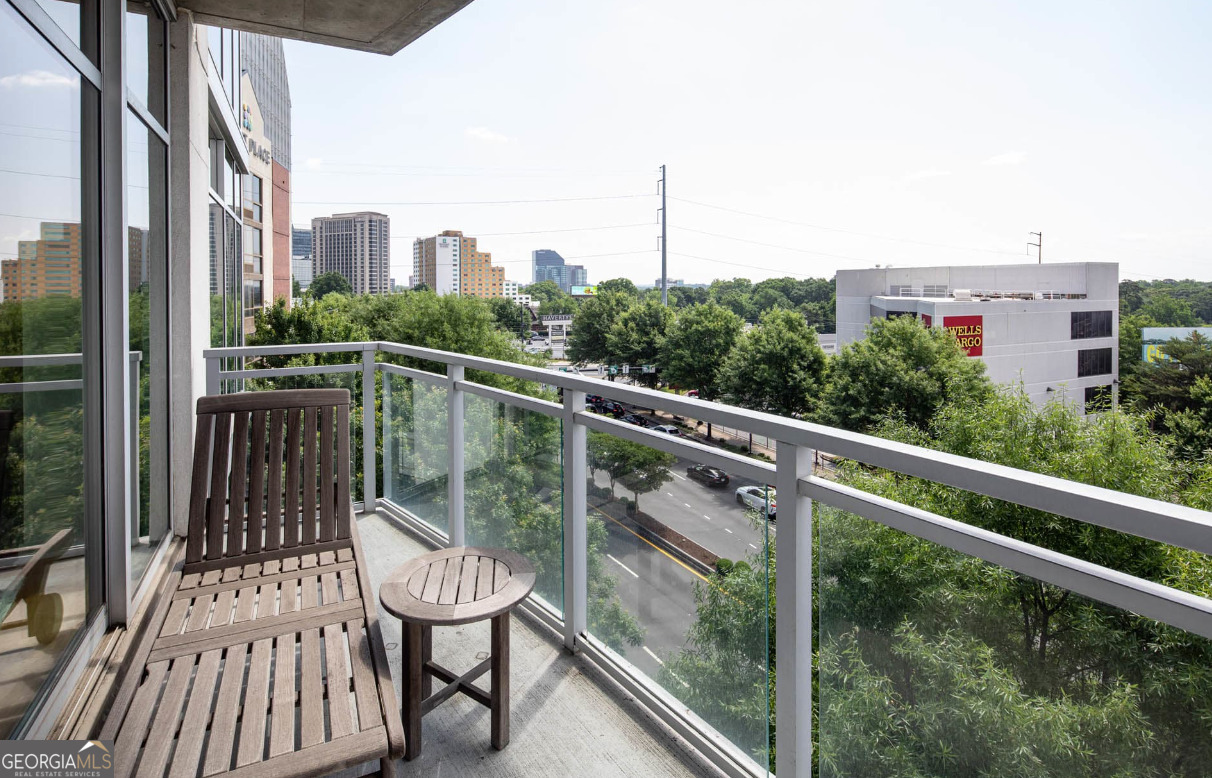 3242 Peachtree Road Northeast, Unit 1408 Atlanta, GA 30305 - Photo 25 of 41 a view of a balcony with two chairs and a wooden fence