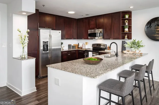 a kitchen with stainless steel appliances granite countertop a stove a sink dishwasher a refrigerator and a microwave