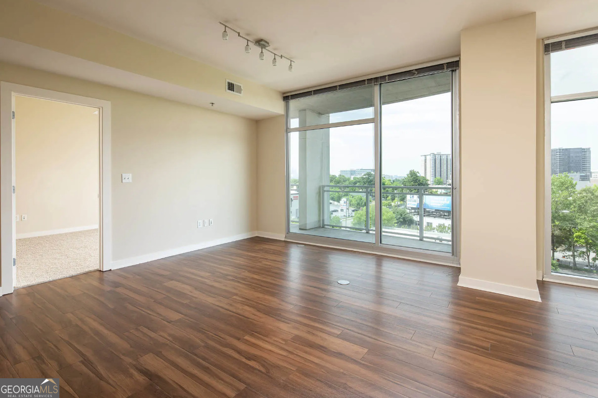 3242 Peachtree Road Northeast, Unit 1408 Atlanta, GA 30305 - Photo 8 of 41 a view of empty room with wooden floor and fan