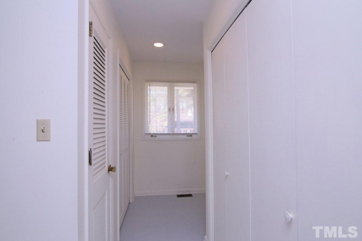 5416 Alpine Drive Raleigh, NC 27609 - Photo 14 of 25 Washer and dryer hookups in closet in this hallway. The hallway leads to the full bath and guest bedroom downstairs which is also off the entrance hall.