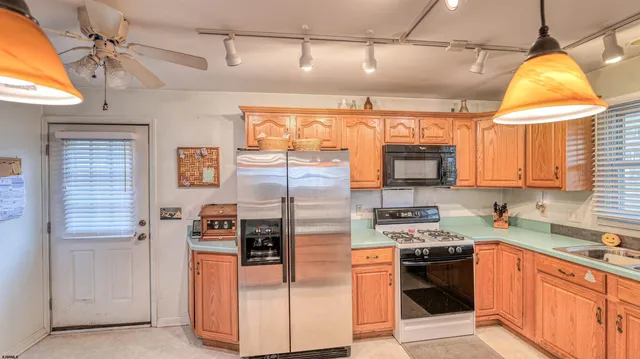 a kitchen with stainless steel appliances granite countertop a refrigerator and a stove