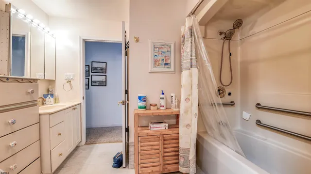 a bathroom with a bathtub sink and mirror