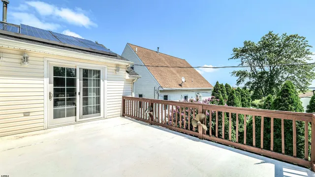 a view of a house with wooden stairs and a large window