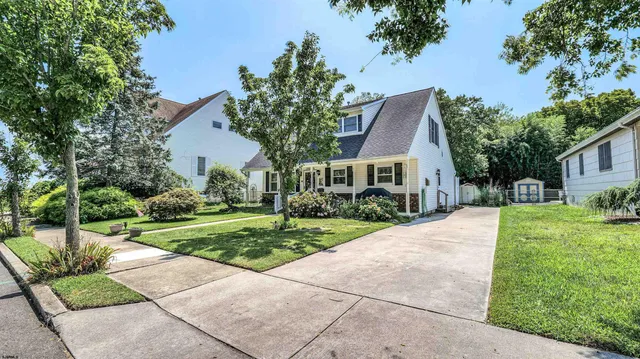 a front view of a house with a yard and potted plants