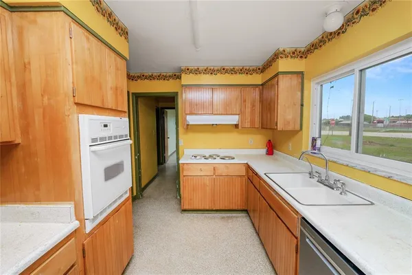 a kitchen with a stove a sink and a window