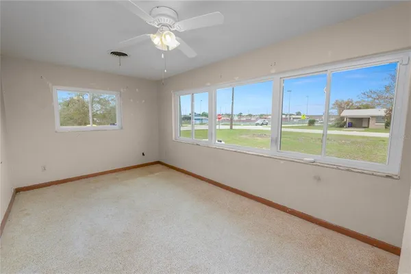 a view of an empty room with a chandelier fan