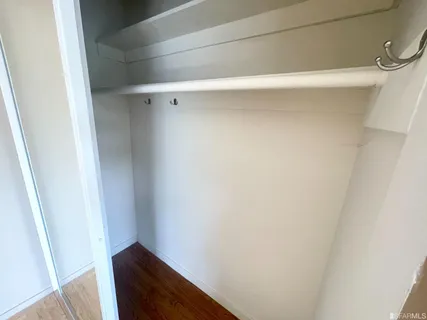 a view of a room with a large window and wooden floor