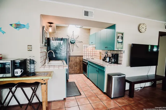 a living room with stainless steel appliances furniture a rug and a view