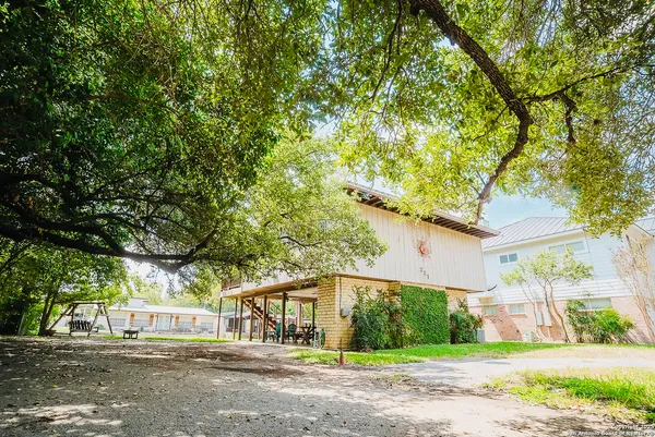 a front view of a house with a yard and potted plants