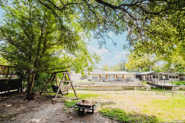 a view of a swimming pool with a patio and wooden fence