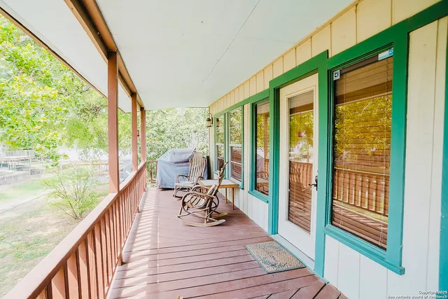 a balcony with wooden floor table and chairs