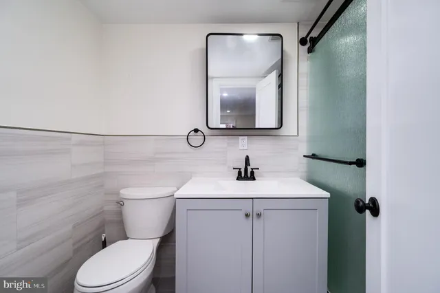 a bathroom with a toilet a sink and mirror
