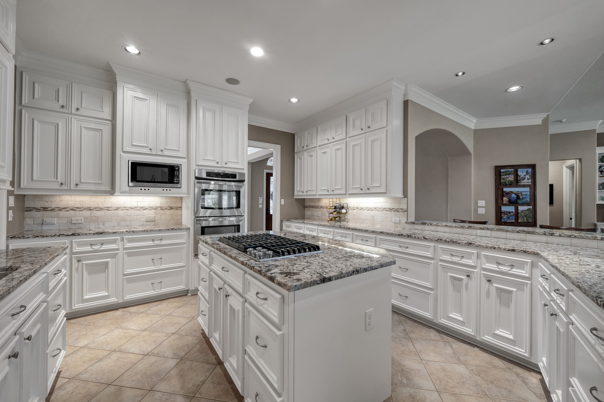 16318 Perry Pass Court Spring, TX 77379 - Photo 11 of 49 This kitchen sparkles with stainless appliances including a double oven, microwave, a five-burner gas cooktop with downdraft. The walk-in pantry is right off the kitchen and there is a timer for outdoor eave lighting for Christmas lights!