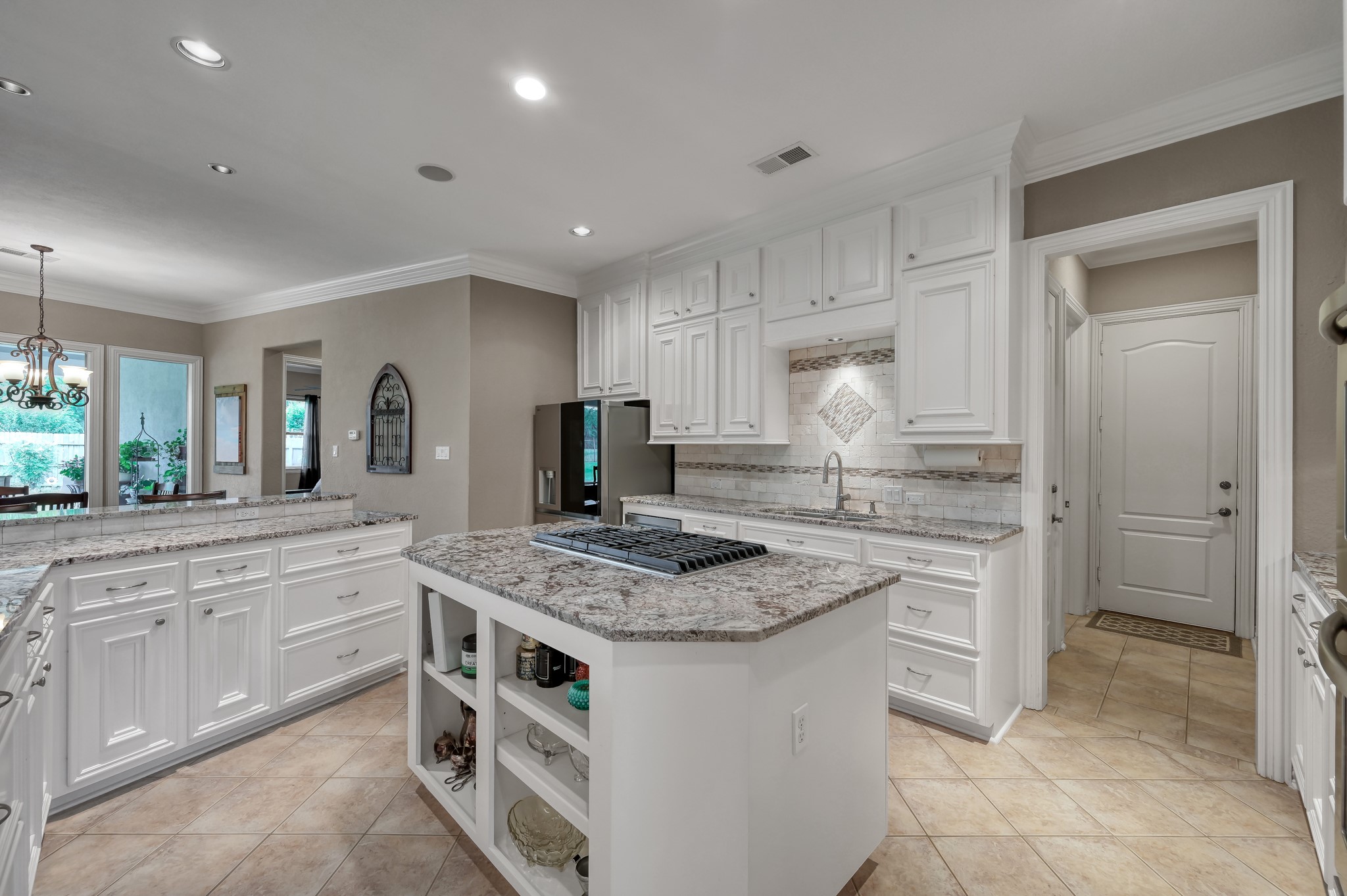 16318 Perry Pass Court Spring, TX 77379 - Photo 13 of 49 There is an abundance of beautiful granite countertops, and a stacked marble backsplash with an accent band and decorative medallion above the kitchen sink.