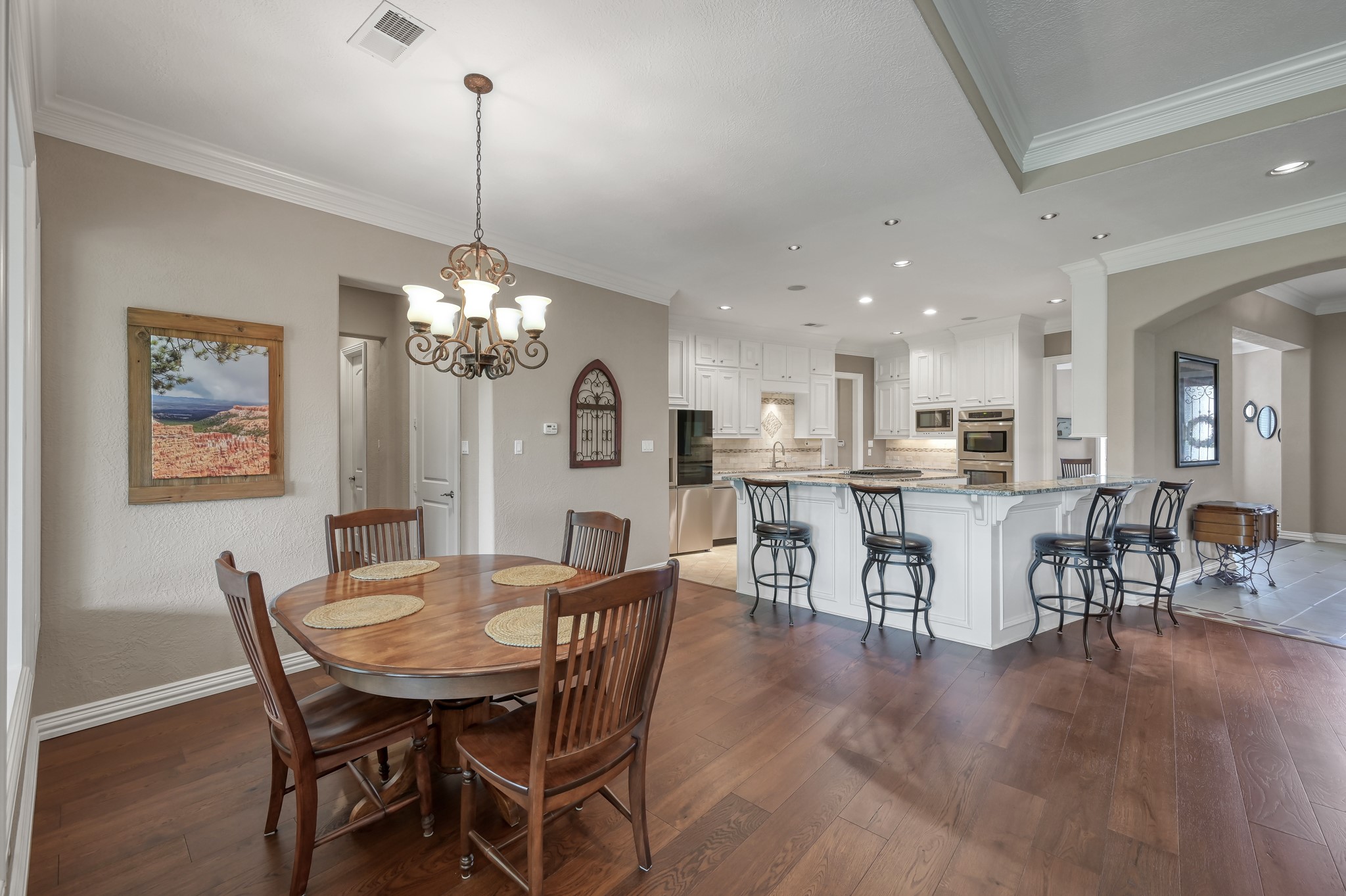16318 Perry Pass Court Spring, TX 77379 - Photo 15 of 49 The open breakfast area is adorned with a bronze finished chandelier, and the hallway leads to the secondary bedrooms.