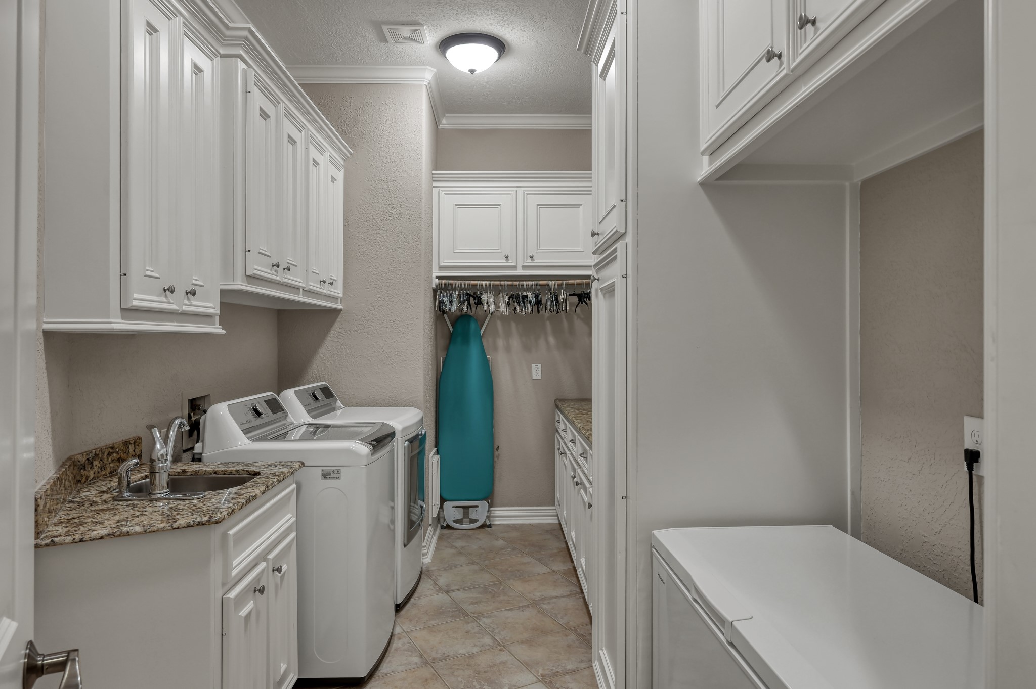 16318 Perry Pass Court Spring, TX 77379 - Photo 19 of 49 Wow, check out this laundry room! Upper and lower cabinet storage, a wet sink, folding counter and room for a freezer!