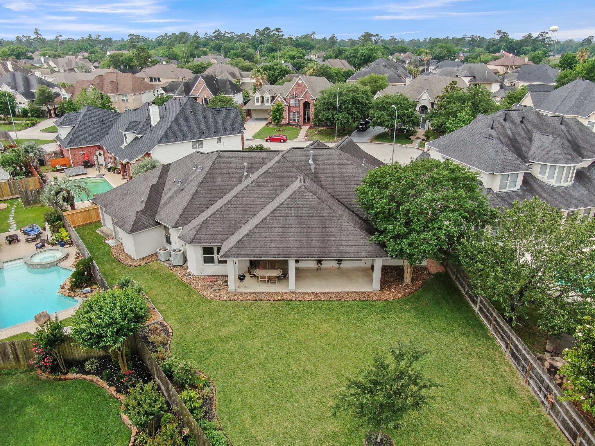 16318 Perry Pass Court Spring, TX 77379 - Photo 41 of 49 This aerial view showcases the large patio, landscape beds and the overhead door opening on the left side of the frame.