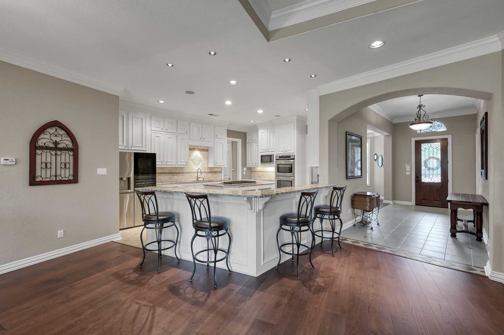 16318 Perry Pass Court Spring, TX 77379 - Photo 10 of 49 The kitchen is open to the family room and has a large breakfast bar accented with corbels and wainscoting. This open area offers cooking with a view!