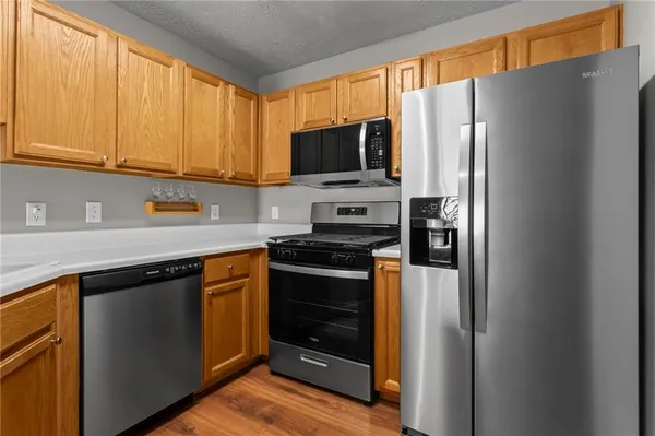 a kitchen with stainless steel appliances granite countertop a refrigerator stove and microwave