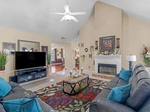 a living room with furniture a flat screen tv and a fireplace