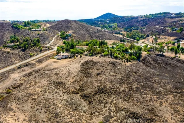 a view of a dry field with mountains in the background