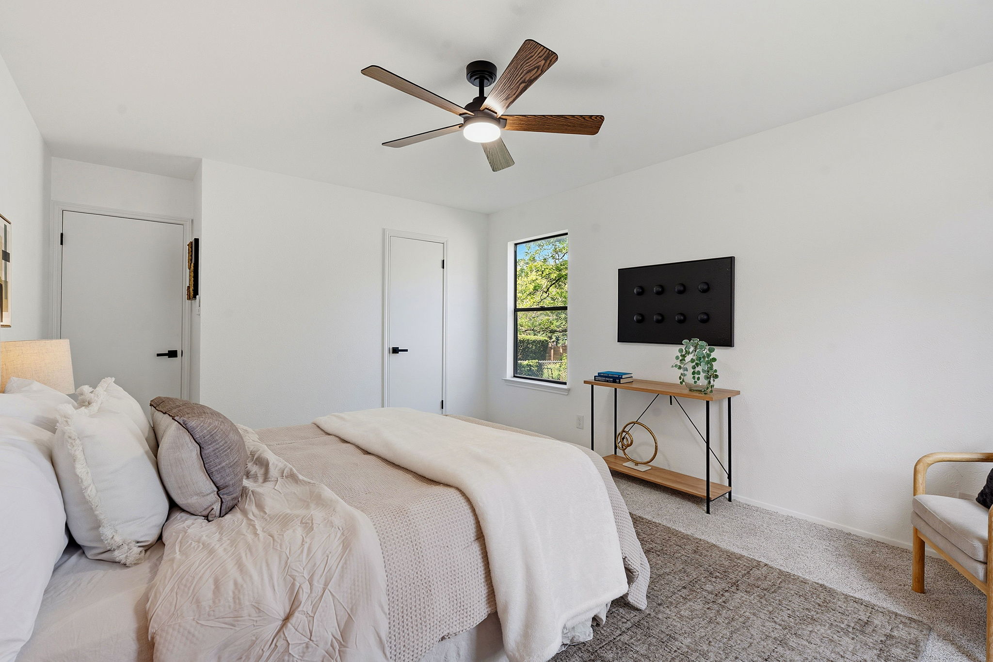 2702 Calabash Cove Austin, TX 78745 - Photo 26 of 40 a bedroom with a bed a window and a flat screen tv
