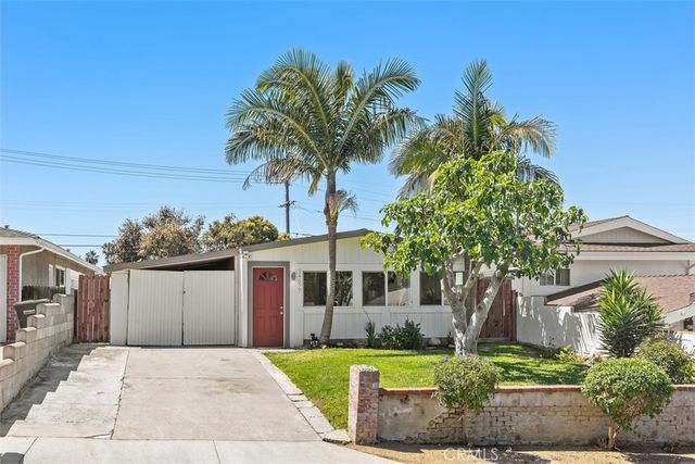 a front view of a house with a garden and trees