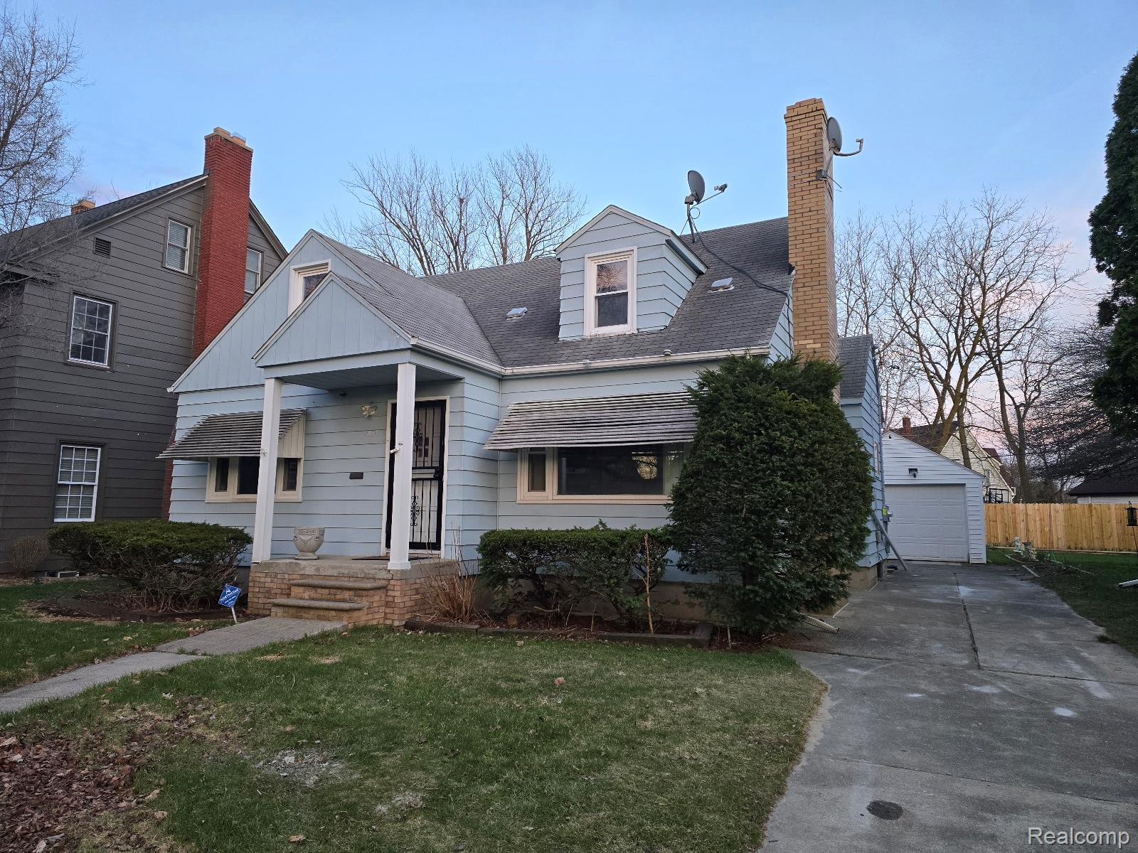 803 Commonwealth Avenue Flint, MI 48503 - Photo 2 of 15 Cape cod-style house with a chimney, a detached garage, an outdoor structure, and roof with shingles
