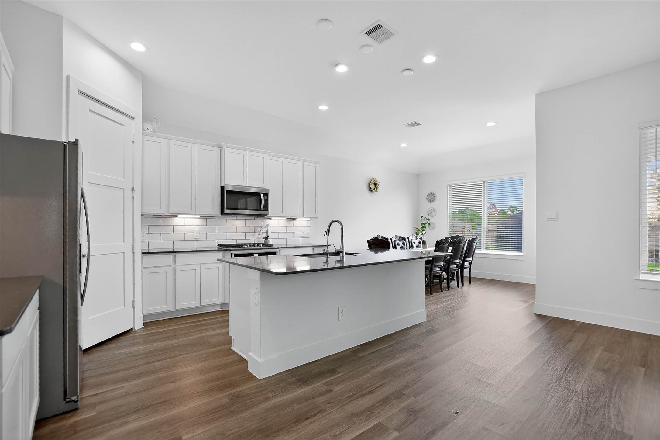13760 Rising Sun Lane Conroe, TX 77384 - Photo 13 of 43 a kitchen with white cabinets and stainless steel appliances