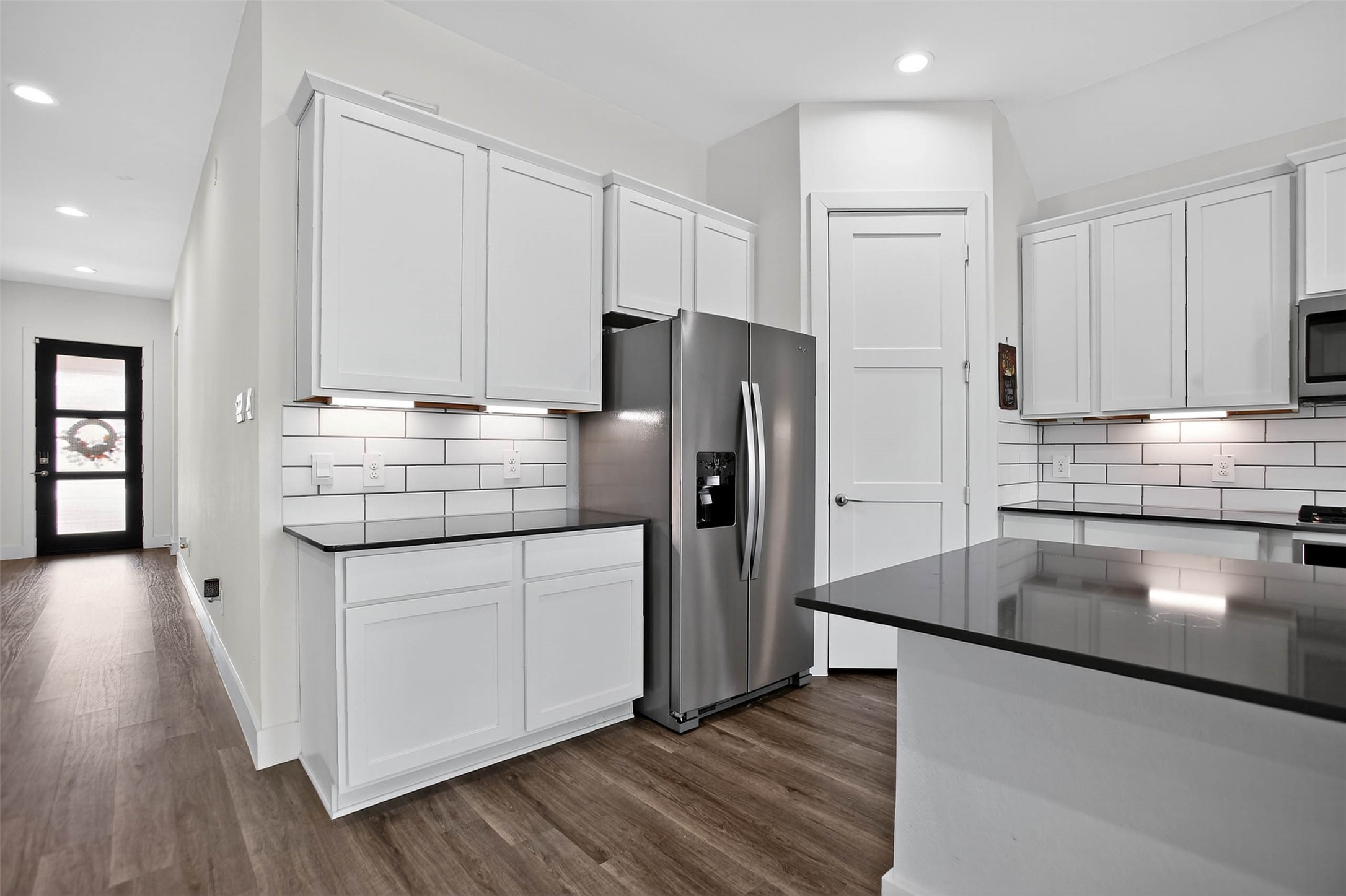 13760 Rising Sun Lane Conroe, TX 77384 - Photo 16 of 43 a kitchen with kitchen island a counter top space a stove and wooden floors